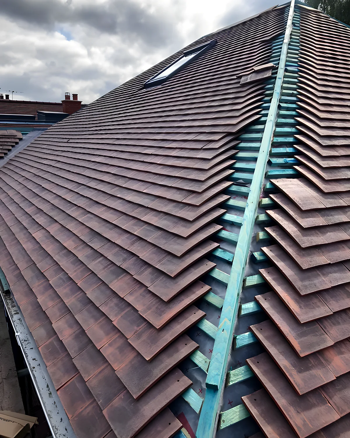 Terracotta clay tiled roof with a bedded ridge running up to the apex