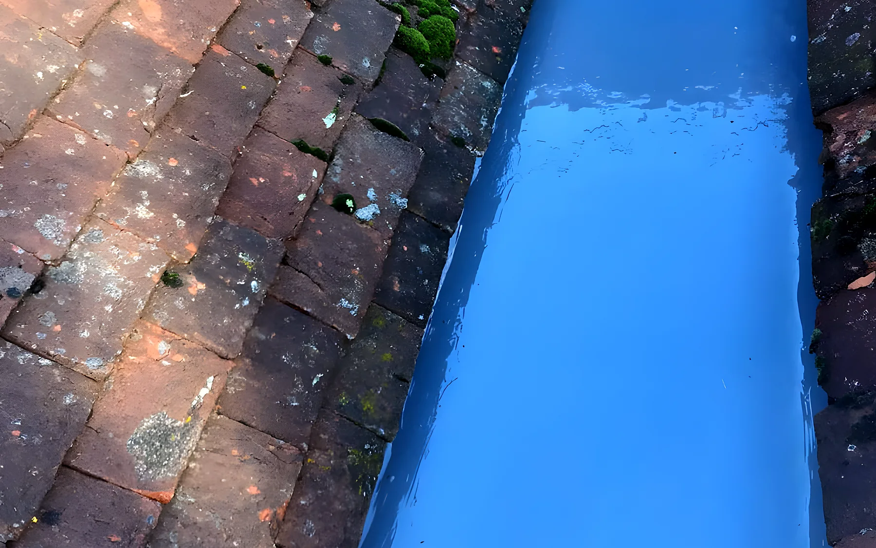 A valley relined in GRP between two tiled roofs