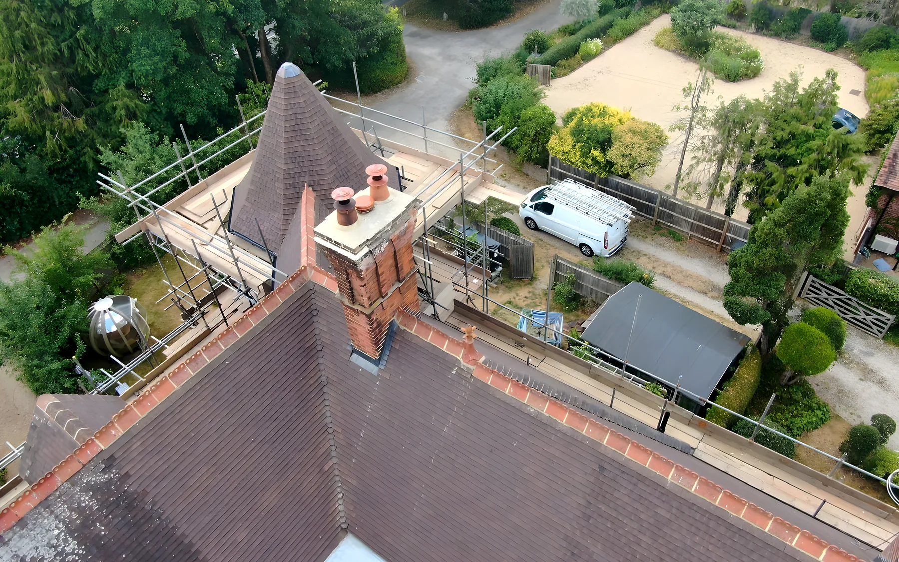 The new clay tiled roof and turret of a Victorian house, photographed from above