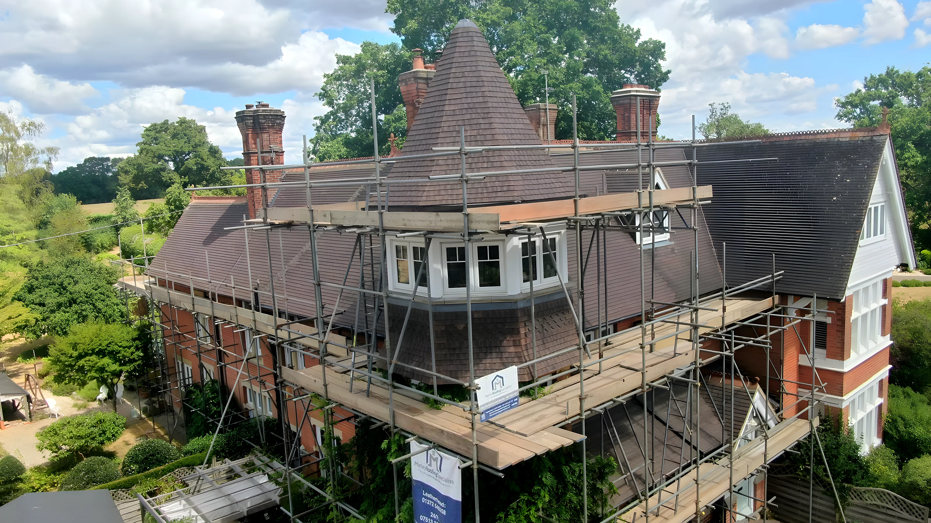 New battens and underlay across a stripped roof with slates being loaded out