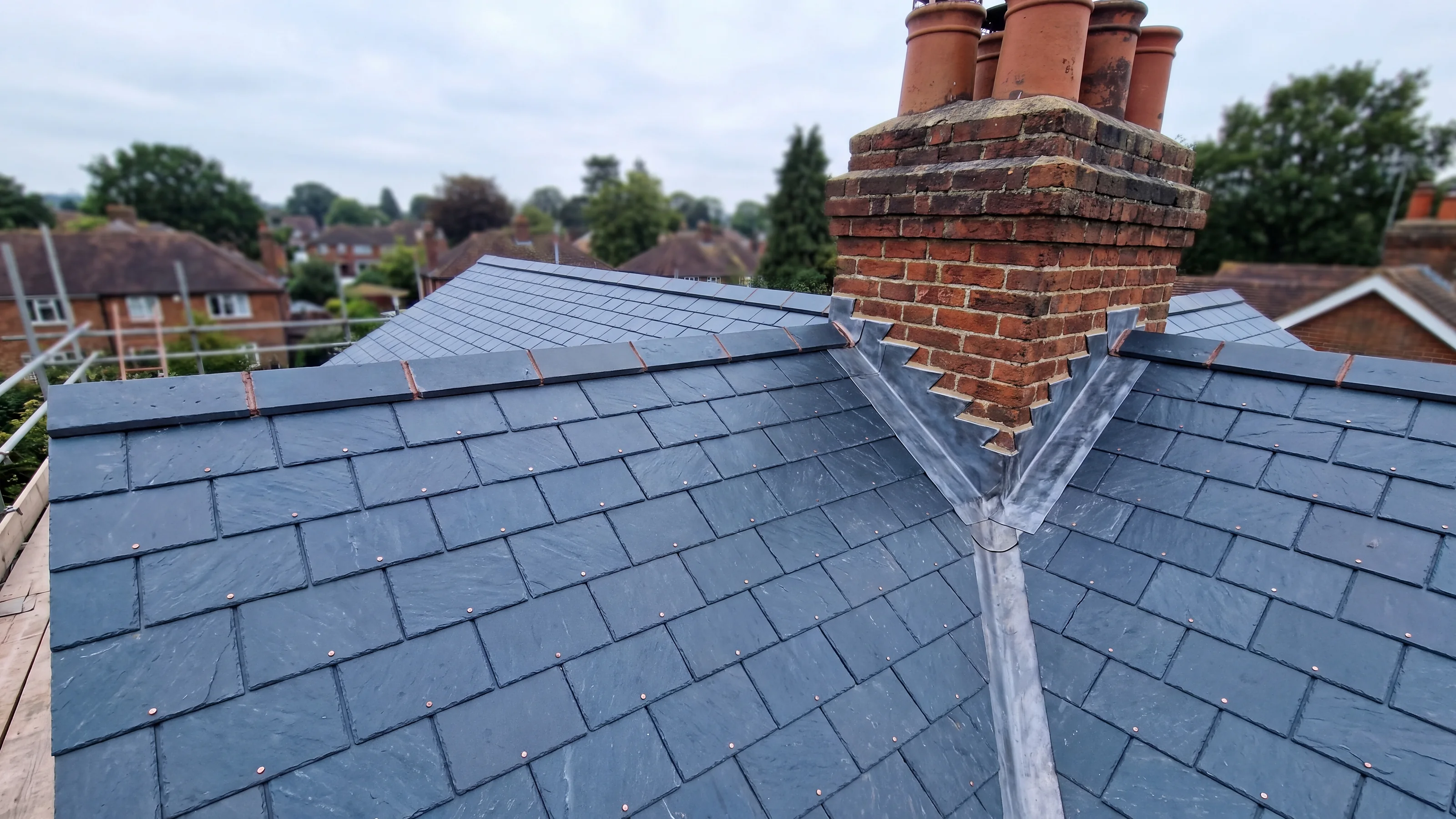 Roofers at work on a scaffold with the Marley banner