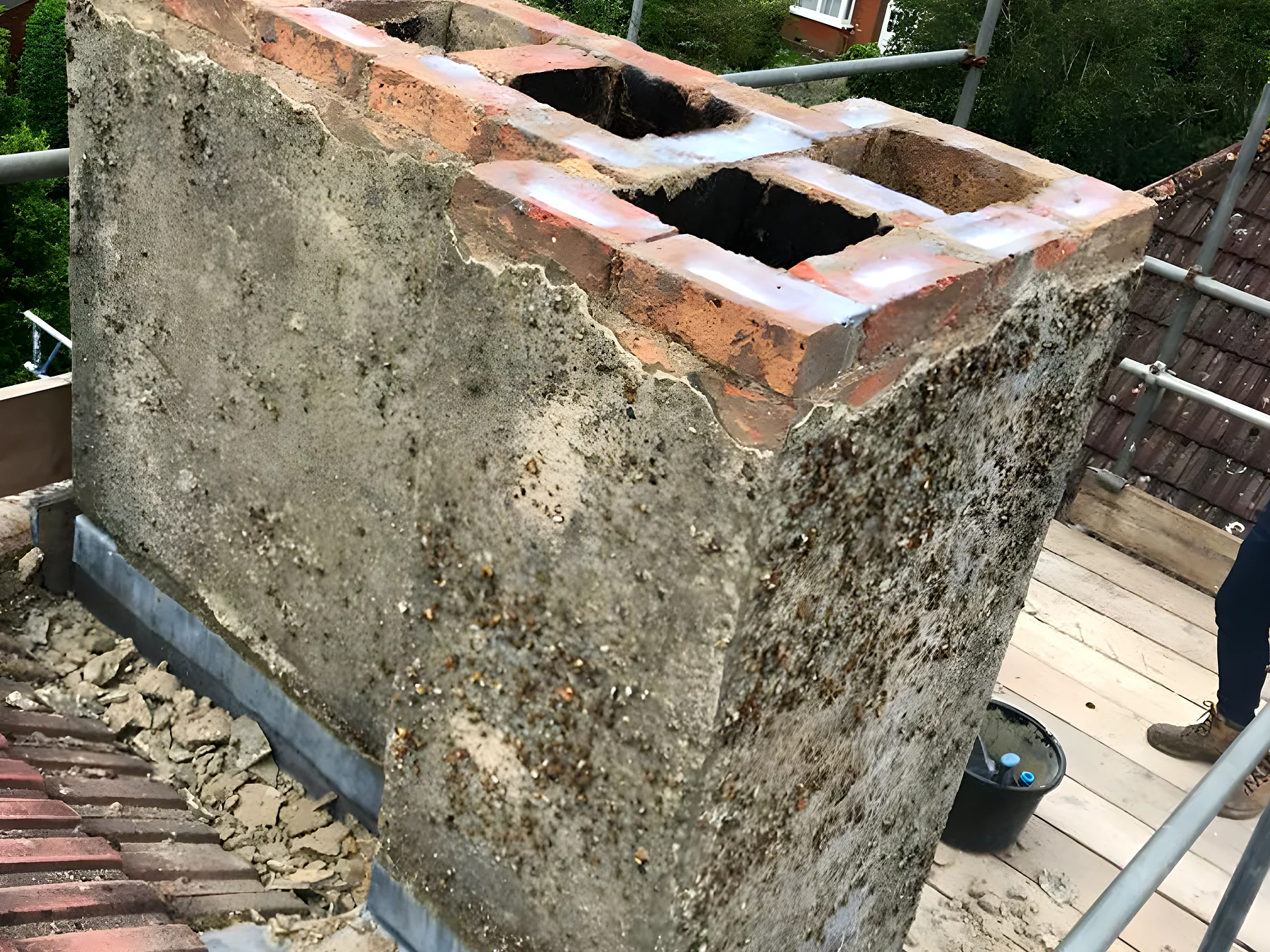 A rendered chimney stack being repaired from the scaffold