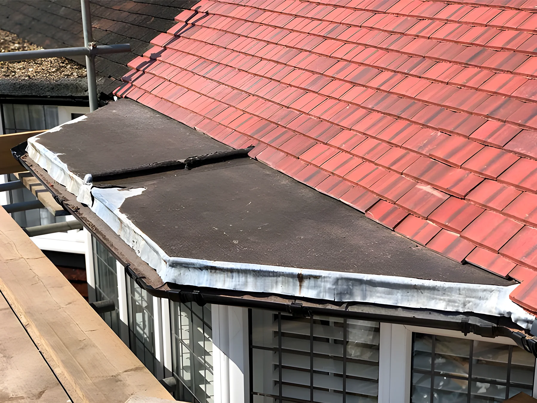 Red tiles meeting a flat roof