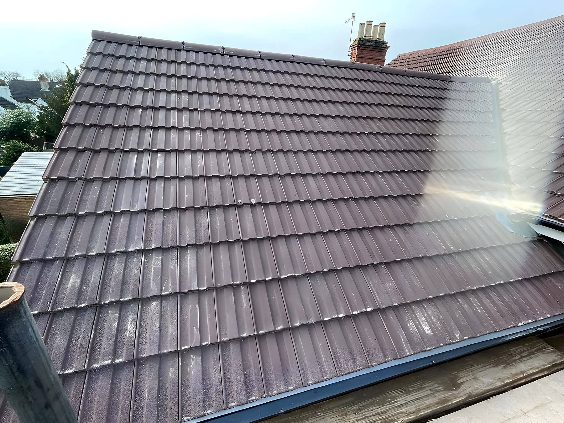 A newly tiled roof slope against a blue sky