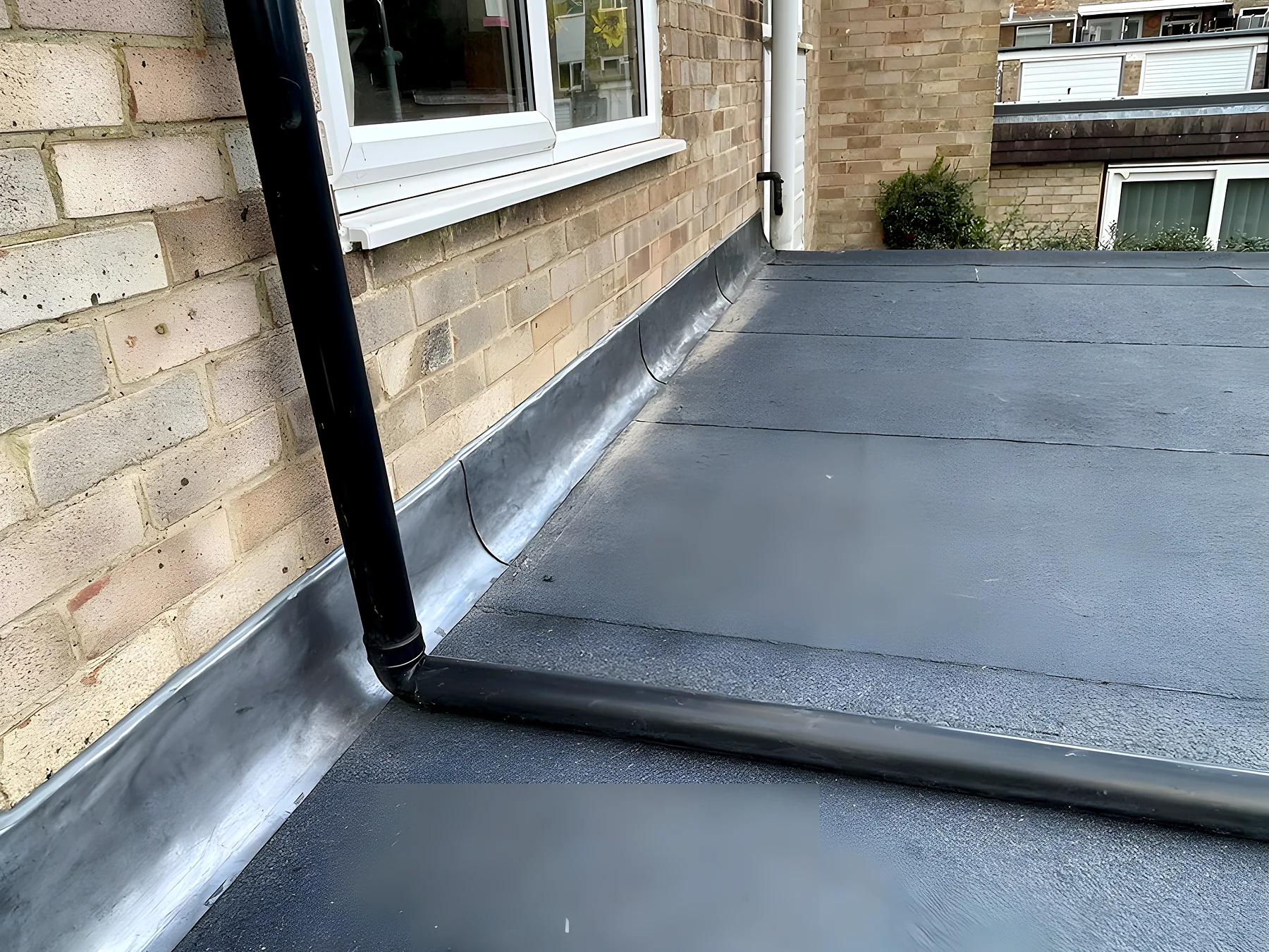 A finished flat roof in grey mineral felt