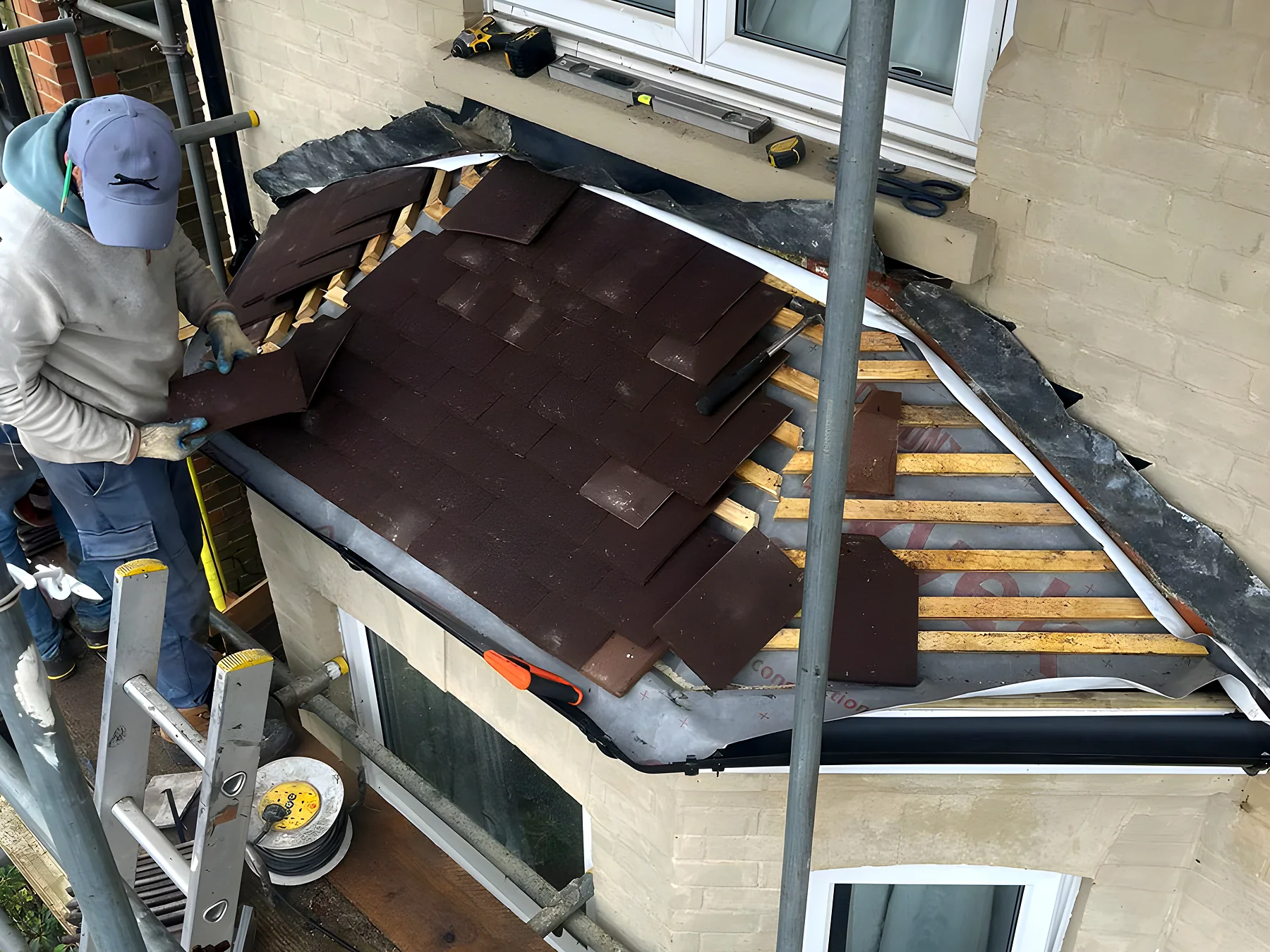 One of our roofers laying new tiles around a dormer