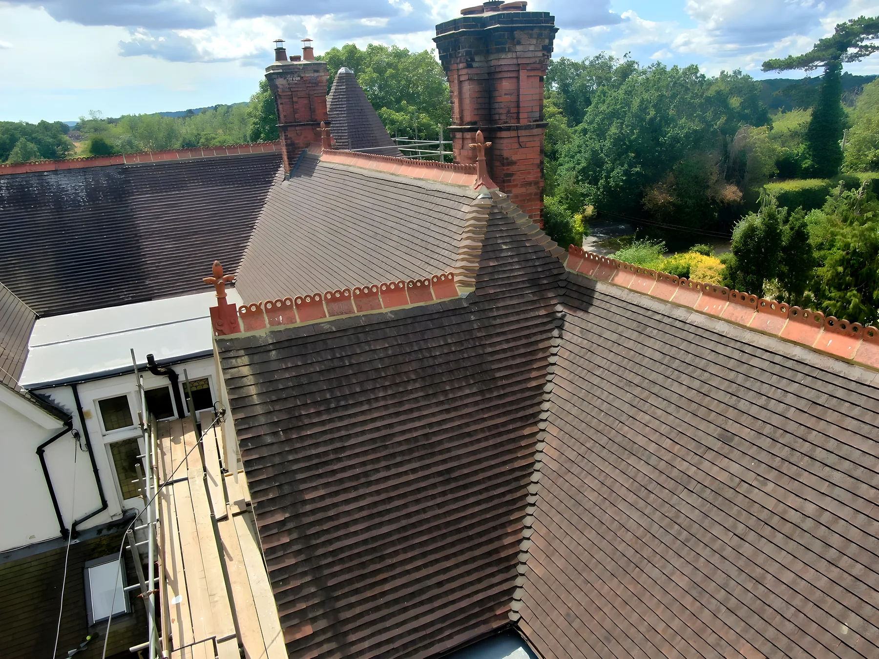 New plain tiles, ornamental ridge and chimneys from scaffold height