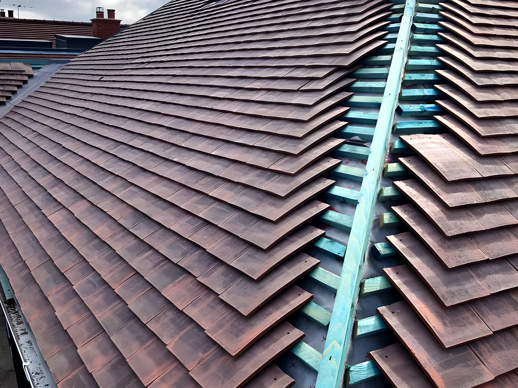 Clay plain tiles being laid over new membrane