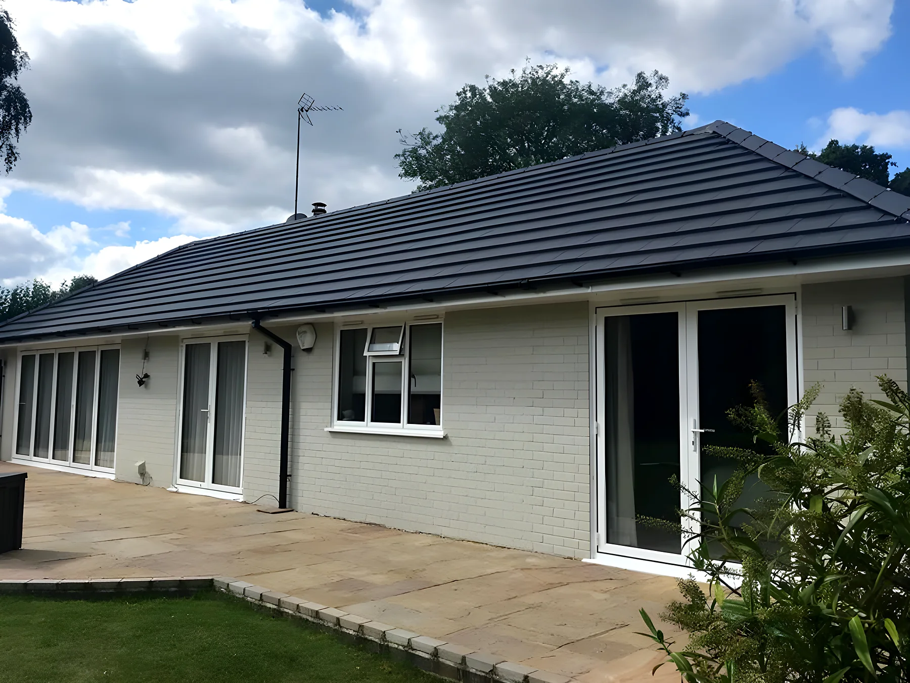 White rendered bungalow finished with a new dark grey tiled roof
