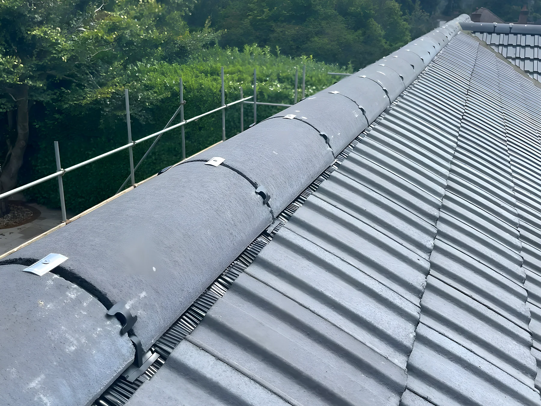 New grey interlocking tiles laid up to the ridge